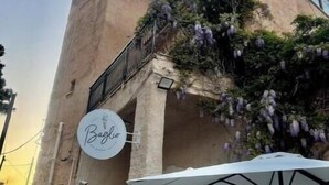 Un bâtiment sur lequel on peut lire l’inscription « Baglio », avec un parasol blanc devant.
