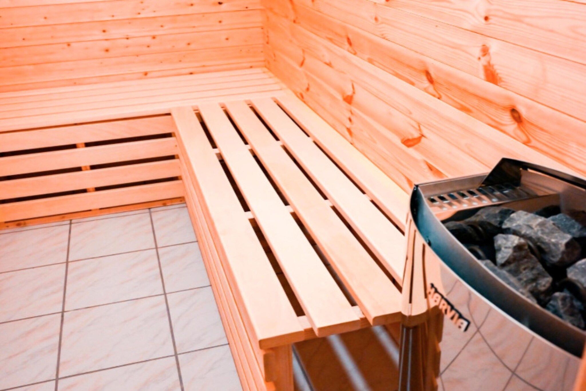 Un sauna avec des bancs en bois et un appareil de chauffage pour sauna.