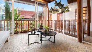 A spacious balcony with a wooden railing, a white sofa, and a table with decorative items. - 5-Star Getsemani Villa | Private Pool | Sleeps 18 (Cartagena de Indias)