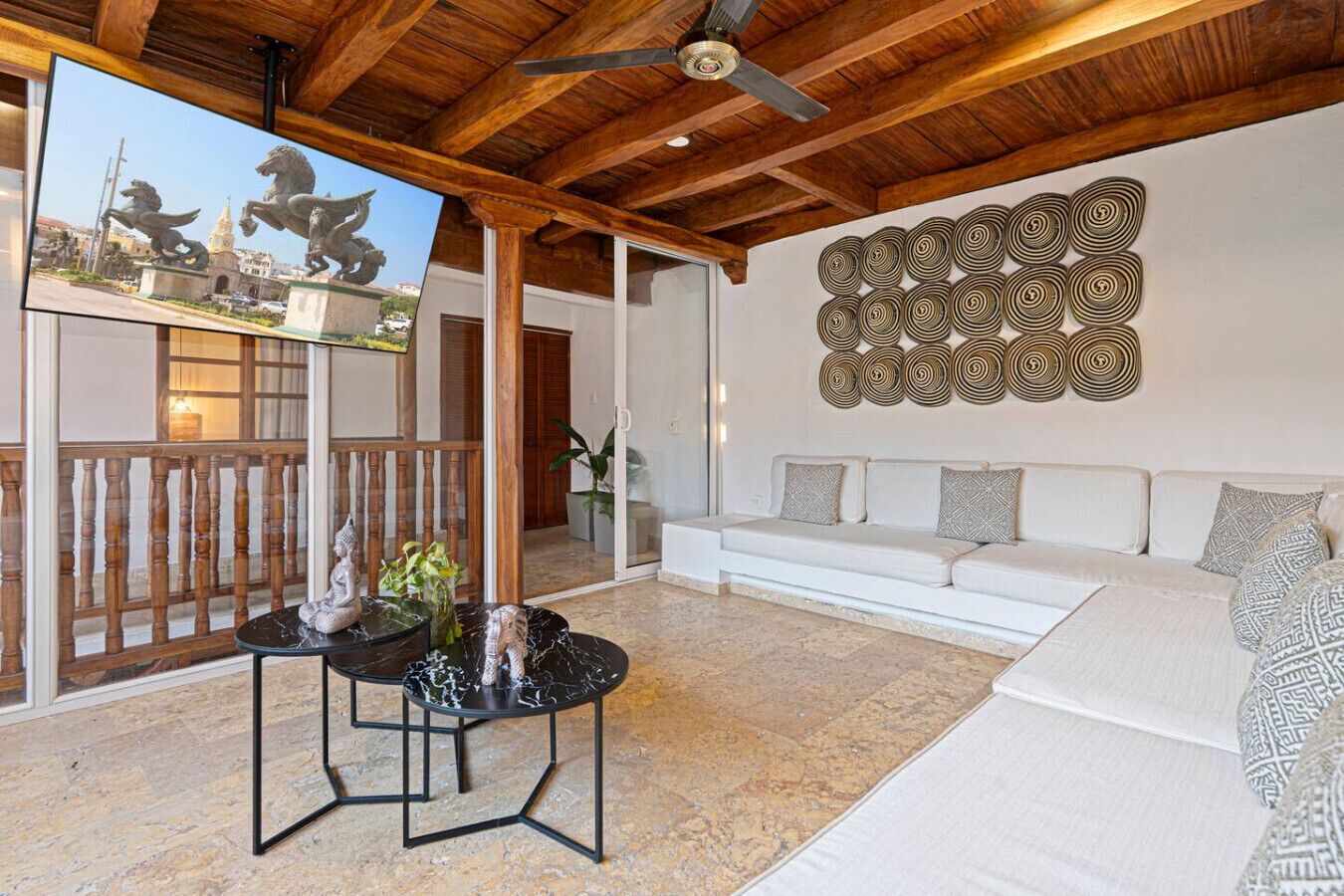 Un salon moderne avec un canapé blanc, une table basse en marbre et un élément décoratif mural.