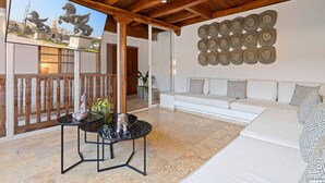 A modern living room with a white sofa, a marble coffee table, and a decorative wall piece. - 5-Star Getsemani Villa | Private Pool | Sleeps 18 (Cartagena de Indias)