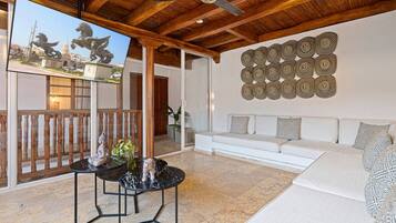 Un salon moderne avec un canapé blanc, une table basse en marbre et un élément décoratif mural.