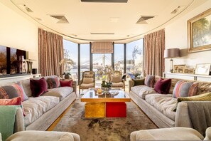 Ein geräumiges Wohnzimmer mit großem Fenster, zwei Sofas, einem Couchtisch und Blick auf eine Brücke.