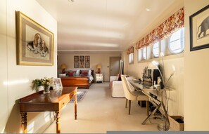 Une chambre à coucher avec un lit, des tables de chevet, un bureau et une chaise.