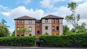 A two-story building with a brick facade, multiple windows, and a flat roof. - Spacious 2BR - Parking Near Edinburgh City Centre (Edinburgh)