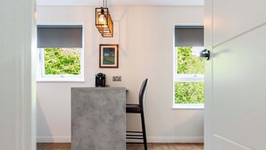 A modern kitchen with a concrete island, black bar stool, and pendant lighting. - Spacious 2BR - Parking Near Edinburgh City Centre (Edinburgh)