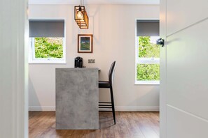 A modern kitchen with a concrete island, black bar stool, and pendant lighting. - Spacious 2BR - Parking Near Edinburgh City Centre (Edinburgh)