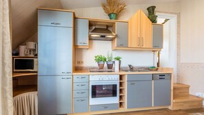 Een kleine keuken met een ingebouwde oven, een magnetron en een vaatwasser.