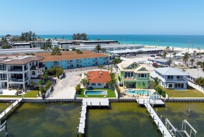 Un hotel costero con varias edificaciones, una piscina y un muelle.