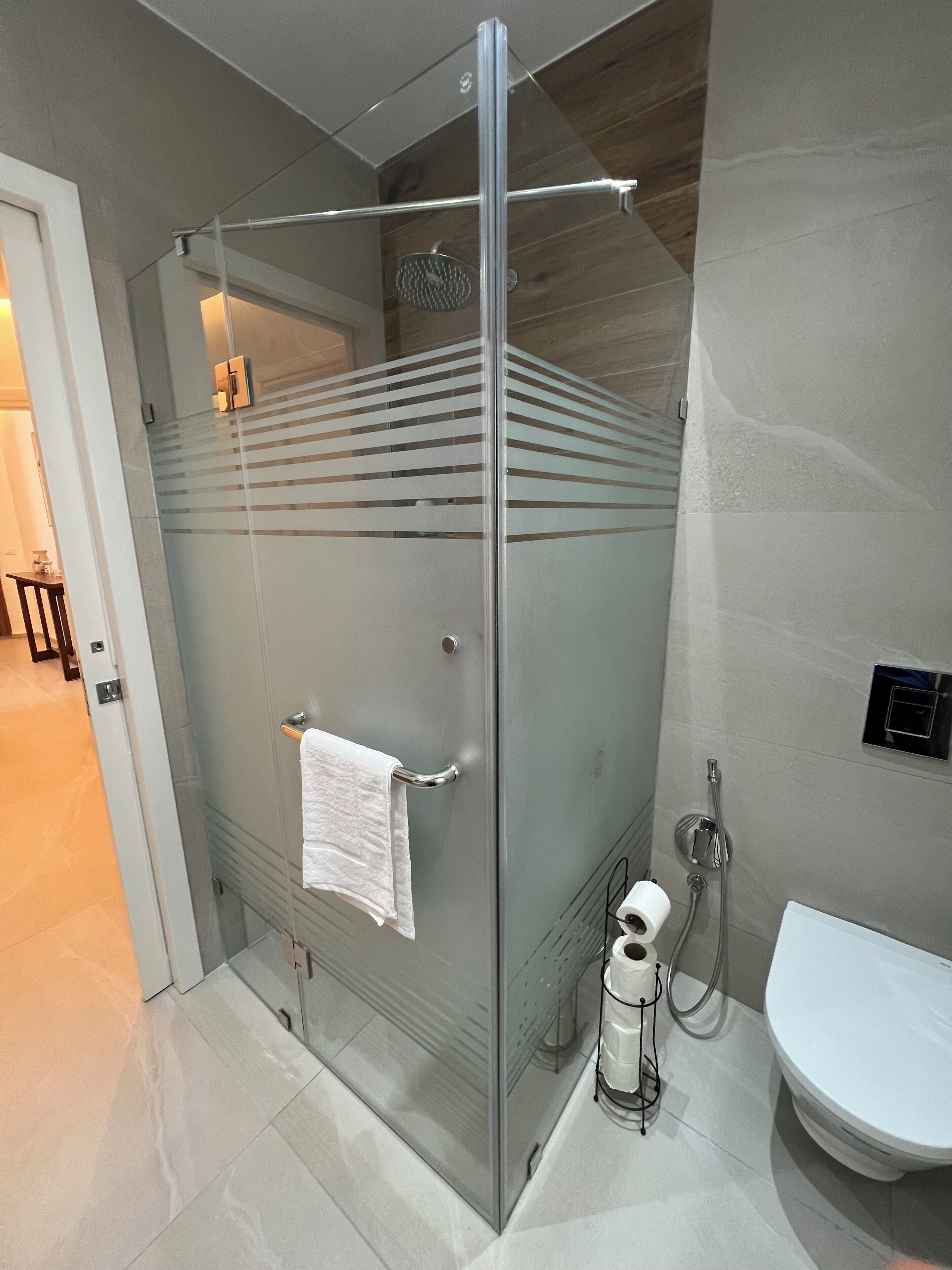 Une salle de bain moderne avec une douche à parois de verre, des toilettes et un lavabo.
