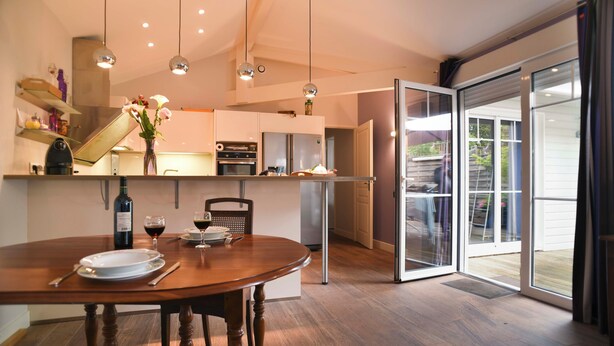 Eine moderne Küche mit Esstisch, Kühlschrank und einer Glastür zum Patio.