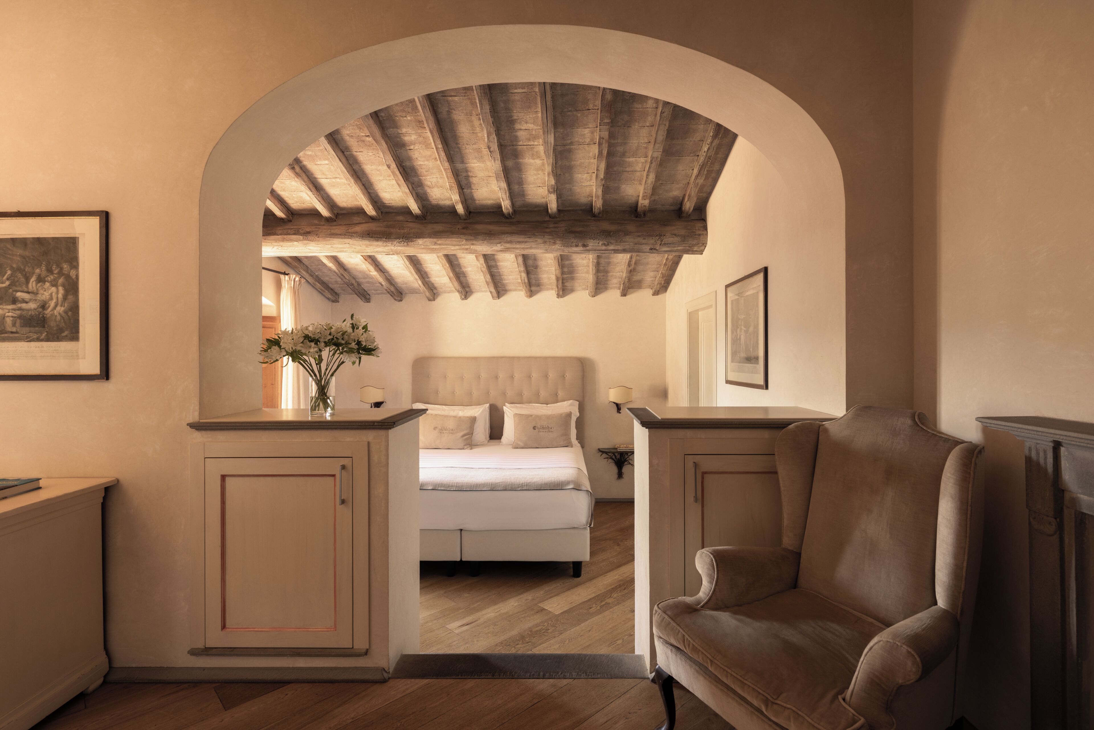 Une chambre avec un grand lit, une chaise et un plafond en bois.