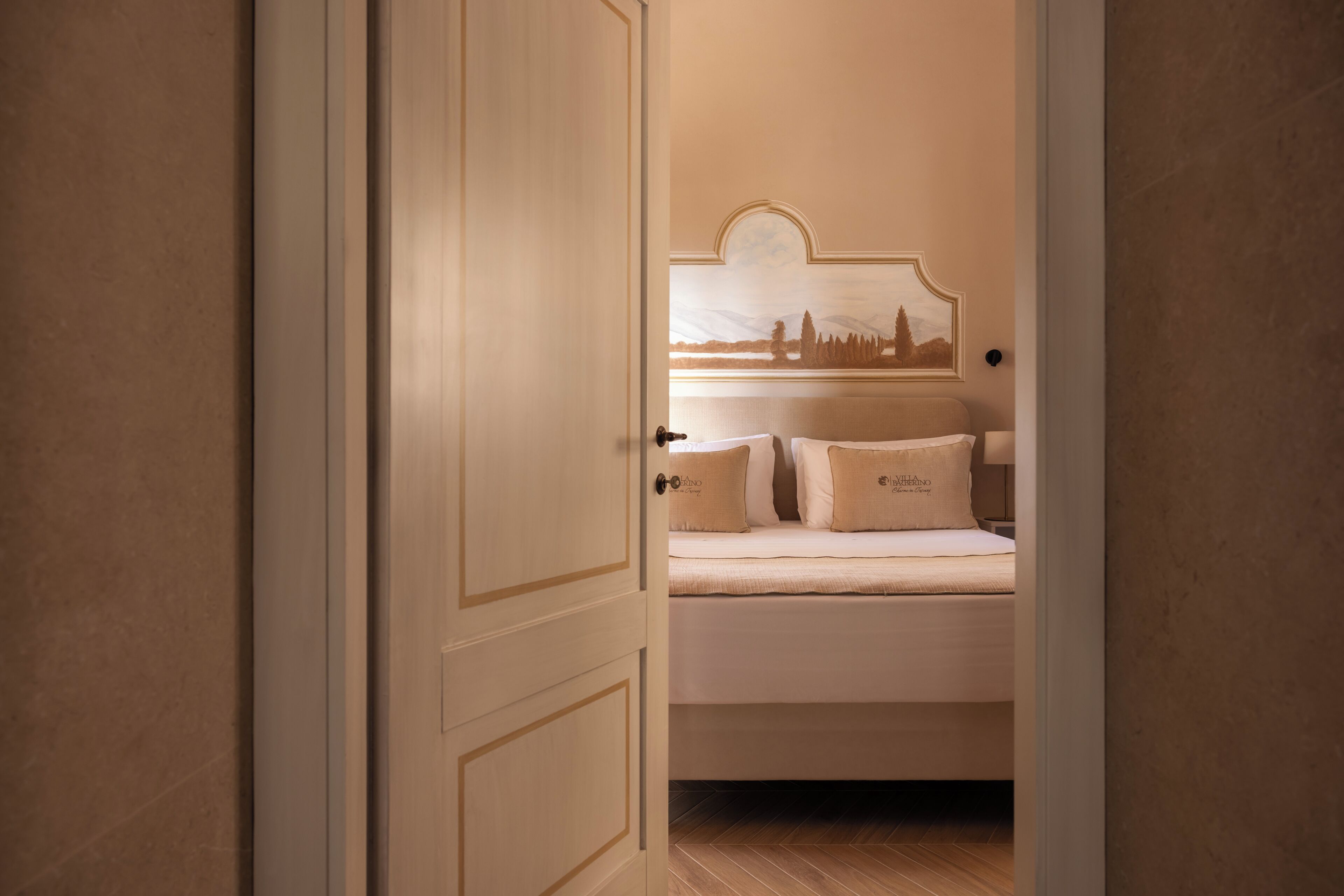 A bedroom with a bed, a nightstand, and a wall-mounted lamp.