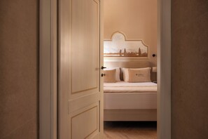 Un dormitorio con una cama, una mesita de noche y una lámpara de pared.
