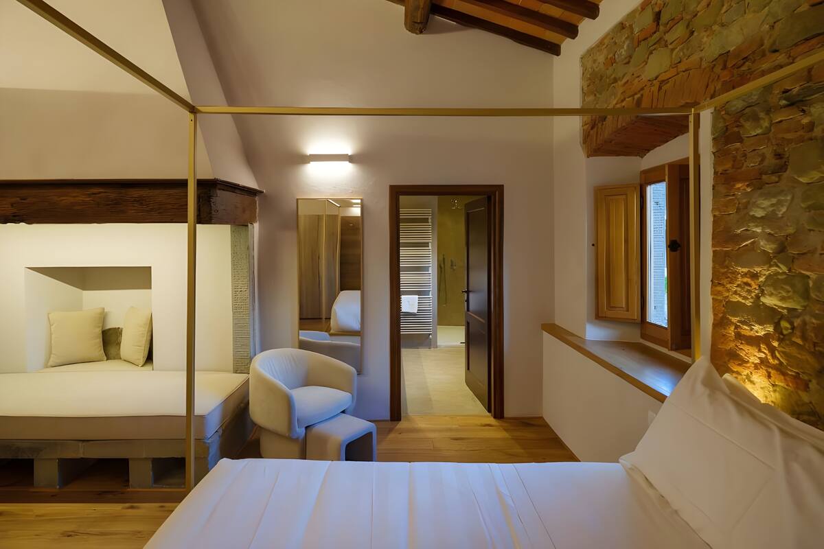Un dormitorio con un armario de espejo, una cama, una silla y techo de madera.