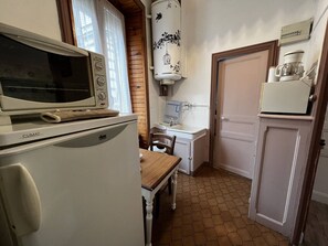A kitchen with a stove, microwave, sink, and refrigerator.