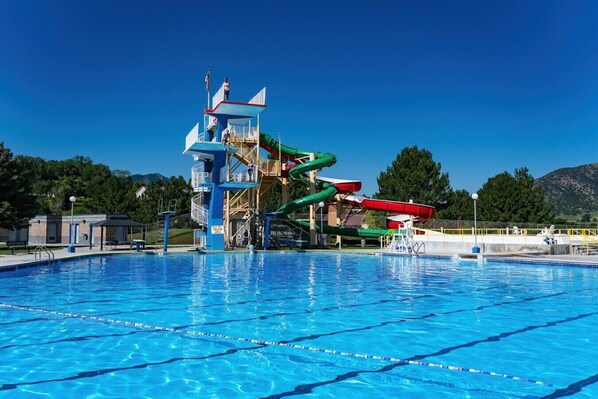 Uma piscina com escorregador e torre para salva-vidas.