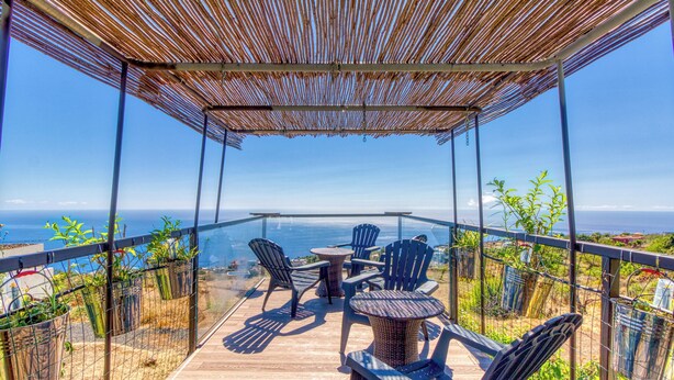 A covered outdoor seating area with chairs and a table, overlooking a scenic view. - Hotel Rural Los Piratas Los Tilos 2 – Apartment with sea view & terrace (Tijarafe)