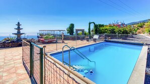 A swimming pool with a fence, a pagoda-like structure, and a view of the sea. - Hotel Rural Los Piratas Los Tilos 2 – Apartment with sea view & terrace (Tijarafe)