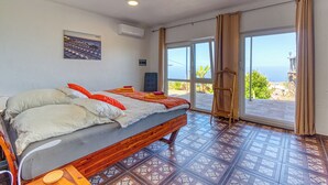 A bedroom with a bed, a window, and a view of the sea. - Hotel Rural Los Piratas Los Tilos 2 – Apartment with sea view & terrace (Tijarafe)