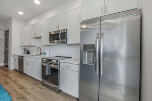 A modern kitchen with white cabinets, stainless steel appliances, and a built-in microwave. - 2 Mi to Downtown Nashville・Spacious Chic Condo (Nashville)