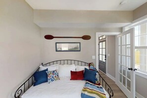 A bedroom with a bed, pillows, a wall-mounted paddle, and a framed picture. - Nashville Lakeview Townhome W Rooftop Deck・Views (Nashville)