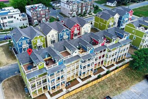 Un edificio residencial de varios pisos con balcones, un patio central y un área de estacionamiento.