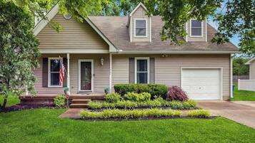 A two-story house with a front porch, a garage, and a well-maintained lawn.