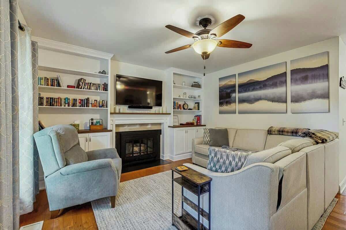A living room with a fireplace, a television, a bookshelf, and a sofa.