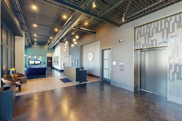 A modern lobby with a reception desk, seating area, and elevators. - Music City Condo・Mins to Broadway W Rooftop Lounge (Nashville)
