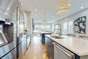 Una cocina moderna con electrodomésticos de acero inoxidable, una isla grande y vistas a la ciudad.