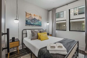 A modern bedroom with a bed, bedside tables, a wall-mounted artwork, and large windows. - Luxury Holiday Home Near Vandy 1 Mile to Music Row (Nashville)