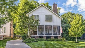 A two-story house with a front porch, a covered entryway, and a brick chimney. - Recently-built all-suite with two porches, firepit, crow's nest, & widow's walk (Franklin)