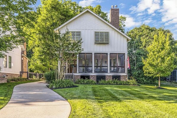 A two-story house with a front porch, a covered entryway, and a brick chimney.