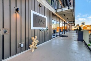 A modern building with a 'hyve' sign, a concrete floor, and a balcony. - Centrally located condo with pool & gym access, balcony, WD & Modern Interior (Nashville)
