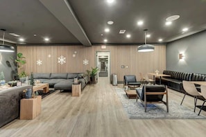 A modern hotel lobby with a sofa, chairs, a coffee table, and a reception desk. - Centrally located condo with pool & gym access, balcony, WD & Modern Interior (Nashville)