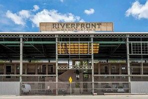 Ein Gebäude mit einem Schild, auf dem 'RIVERFRONT CONDOMINIUMS' steht, und einem überdachten Parkbereich.