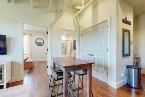 A modern interior with a wooden dining table, metal chairs, a round mirror, and a 'Welcome' sign. - Midtown Nashville Penthouse・Dog OK・Pool・Rooftop (Nashville)