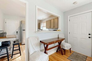 A modern kitchen with white cabinets, a wooden table, and two white chairs. - Cozy Pet Friendly Music City Escape, Near Broadway (Nashville)