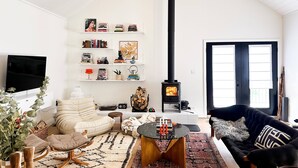 Un salon avec une cheminée, des étagères à livres, un canapé et un téléviseur.
