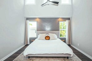 A bedroom with a bed, a ceiling fan, and a window with curtains. - Modern Nashville Escape Near Broadway・Rooftop Deck (Nashville)