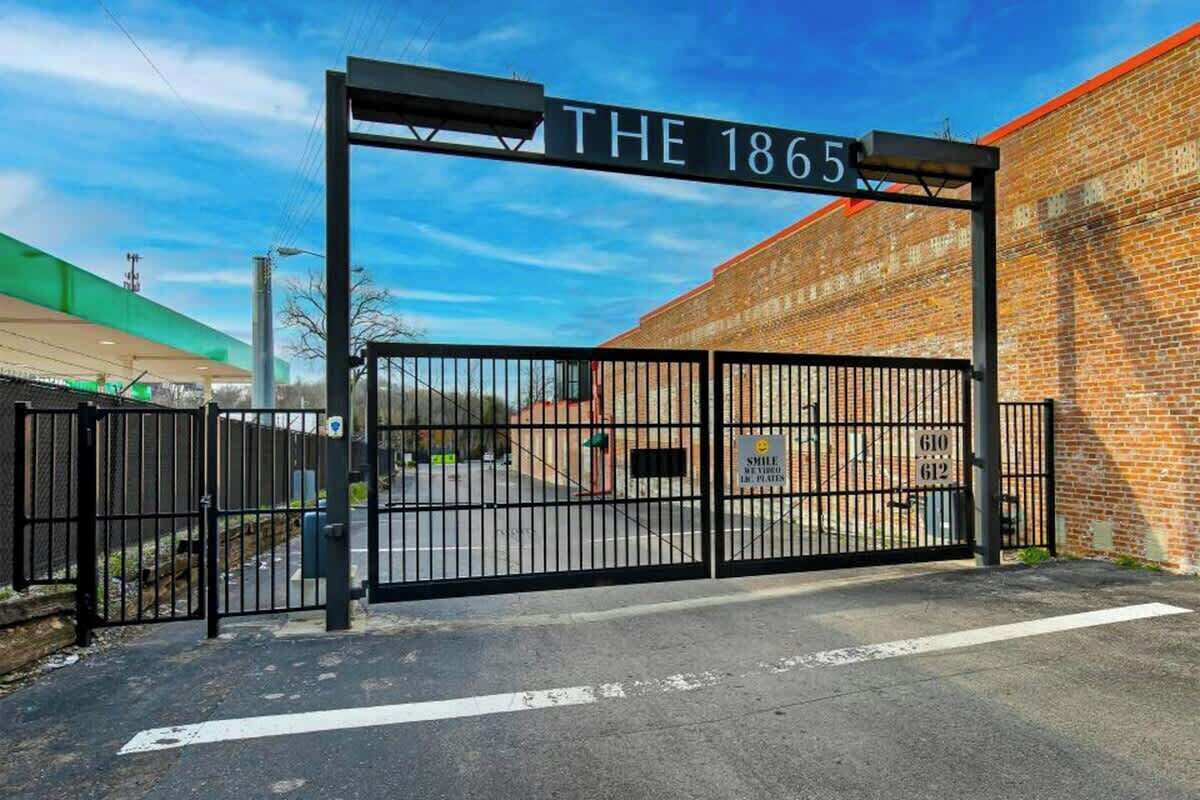 Una entrada con portón y un letrero que dice 'THE 1865'.