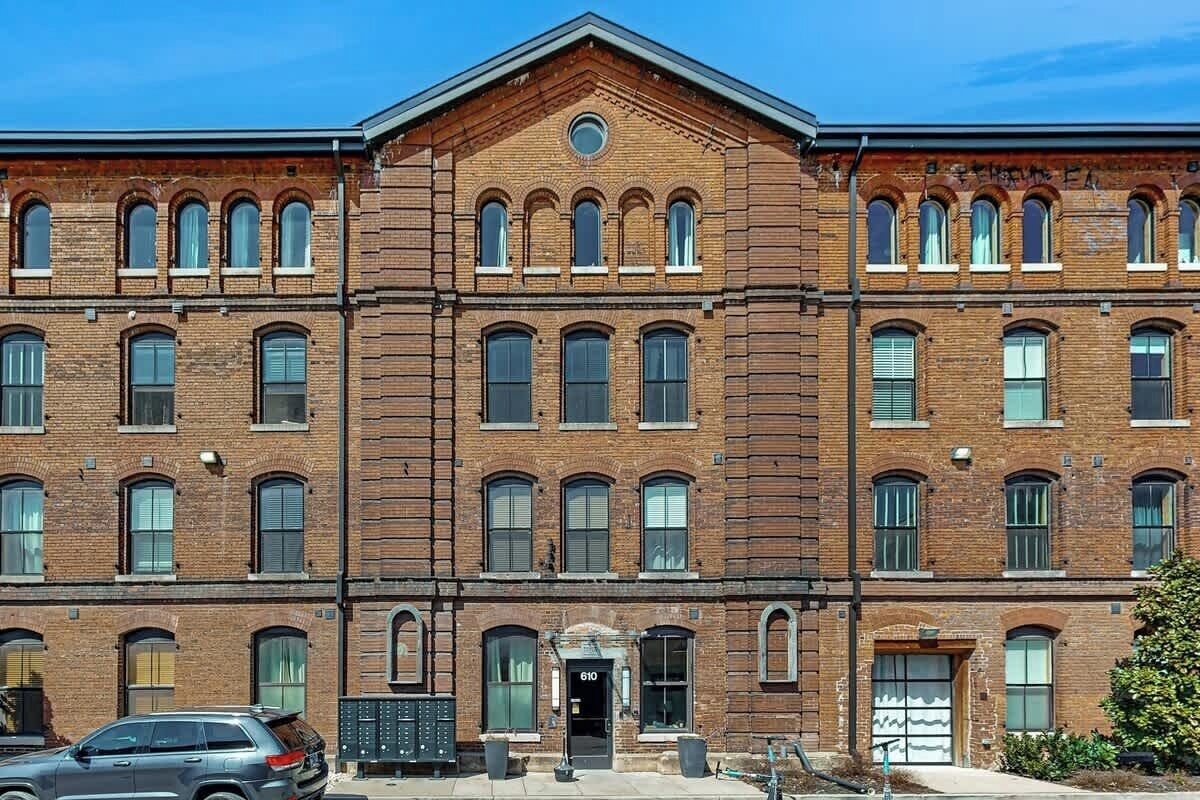 Ein mehrgeschossiges Backsteingebäude mit einem zentralen Eingang, großen Fenstern und einer symmetrischen Fassade.