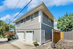 A two-story house with a garage, a wooden fence, and a paved driveway. - 0.2 Mi 12 South・Modern Nashville Getaway, Sleeps 2 (Nashville)