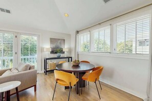 A dining area with a round table, four chairs, a sofa, and a lamp. - 0.2 Mi 12 South・Modern Nashville Getaway, Sleeps 2 (Nashville)