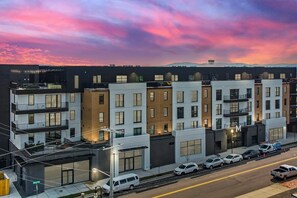 A multi-story residential building with balconies, large windows, and a street view. - Modern Nashville Condo Near Broadway & The Gulch (Nashville)