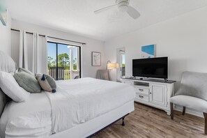 A bedroom with a bed, a TV, a chair, and a ceiling fan. - 🏖️ Romar Village 621 | 2BR Orange Beach Condo | Near Beach + Sleeps 4 (Orange Beach)