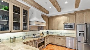 A kitchen with wooden cabinets, a microwave, a refrigerator, a stove, and a dishwasher. - Newly Renovated Condo With Ocean View Luxury Amenities in Beachfront Resort Walk to Downtown (Cabo San Lucas)