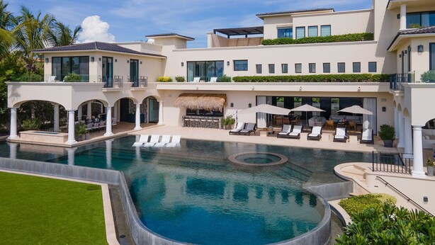 Ein modernes Resort mit großem Schwimmbecken, Liegestühlen und einer Bar.