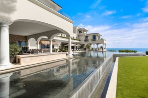 A large, modern house with a swimming pool, outdoor seating, and a view of the ocean. - Breathtaking Villa Boasting a Private Putt Chip Course Gym Tennis Court Resort Access More (San José del Cabo)